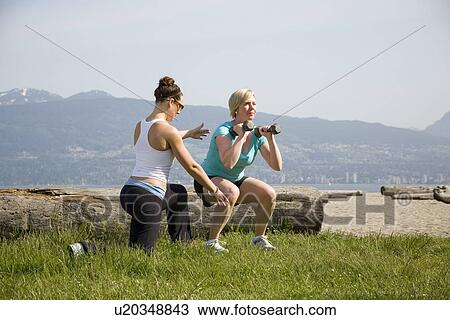 Yoga Instructor and woman using weights in park, Vancouver. BC View Large Photo Image Stock Image - Yoga Instructor and woman using weights in park, Vancouver. BC. Fotosearch