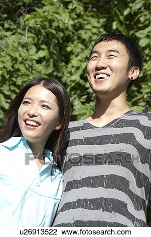 Stock Image - Young couple of Asian ethnicity in Assiniboine Park, Winnipeg, Canada. Fotosearch