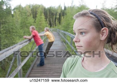 Stock Photo - Young girl looking off on boardwalk nature trail, Riding Mountain National Park, Manitoba, Canada. Fotosearch