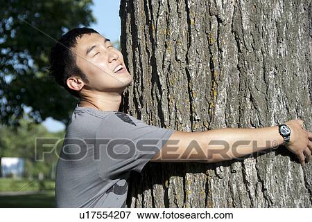 Young man hugs tree, Assiniboine Park, Winnipeg, Canada View Large Photo Image Stock Photo - Young man hugs tree, Assiniboine Park, Winnipeg, Canada. Fotosearch
