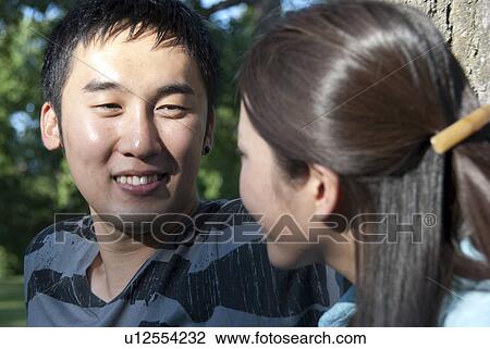 Young man looking at young woman in park, Winnipeg, Canada View Large Photo Image Stock Image - Young man looking at young woman in park, Winnipeg, Canada. Fotosearch