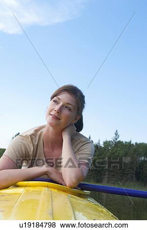 Stock Photo - Young woman seated in kayak, resting, Lake Katherine, Riding Mountain National Park, Manitoba, Canada. Fotosearch