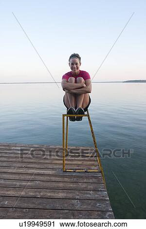 Young woman seated on dock ladder, Clear Lake, Riding Mountain national Park, Mantioba, Canada View Large Photo Image Stock Image - Young woman seated on dock ladder, Clear Lake, Riding Mountain national Park, Mantioba, Canada. Fotosearch