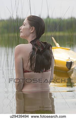 Young woman standing waist deep in lake, Lake Katherine, Riding Mountain National Park, Manitoba, Canada View Large Photo Image Picture - Young woman standing waist deep in lake, Lake Katherine, Riding Mountain National Park, Manitoba, Canada. Fotosearch