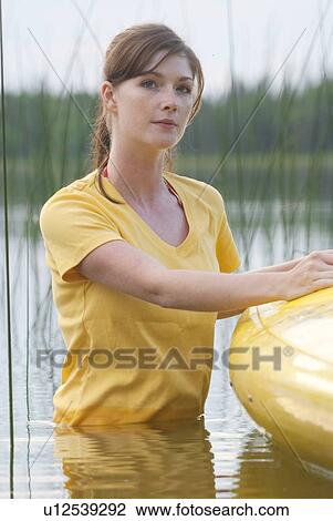Stock Image - Young woman with her hand in the water, in kayak, Lake Katherine, Riding Mountain National Park, Manitoba, Canada. Fotosearch