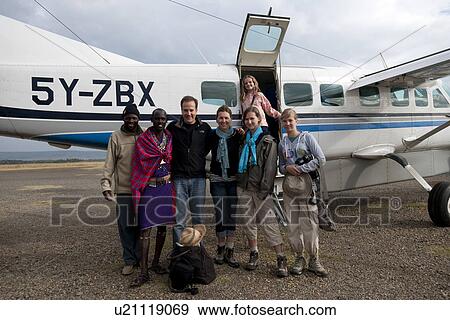 Stock Photo - Family and tour guides by airplane. Fotosearch