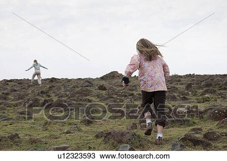 Stock Image - Girl running in field in Kenya. Fotosearch