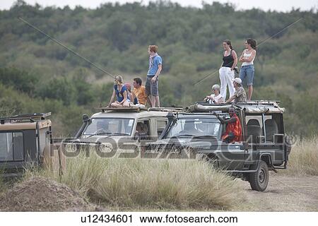 Stock Image - People on safari trucks. Fotosearch