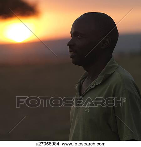Picture - Profile of African man against sunset sky in Kenya Africa. Fotosearch