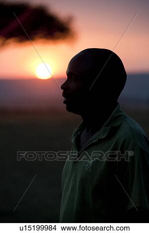 Picture - Sillouette of people against sunset sky in Kenya. Fotosearch