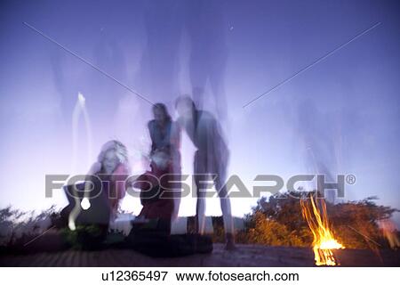 Stock Photo - Tourists around a campfire in Kenya Africa. Fotosearch