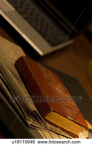 Stock Photo - Antique book with newspaper and laptop. Fotosearch