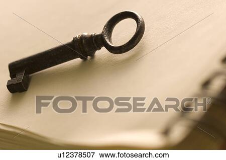 Stock Photo - Antique key on a notebook. Fotosearch