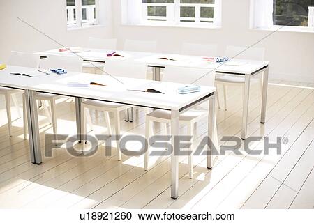 Stock Image - Books and stationery arranged in school classroom. Fotosearch