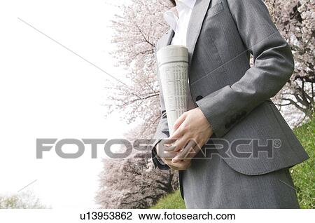 Businesswoman holding a newspaper in a field View Large Photo Image Stock Image - Businesswoman holding a newspaper in a field. Fotosearch
