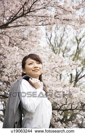 Businesswoman holding her jacket over her shoulder View Large Photo Image Picture - Businesswoman holding her jacket over her shoulder. Fotosearch