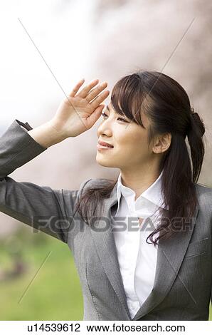 Businesswoman in a field shielding her eyes View Large Photo Image Stock Image - Businesswoman in a field shielding her eyes. Fotosearch