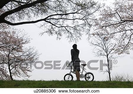 Businesswoman with a bicycle in a field View Large Photo Image Stock Photograph - Businesswoman with a bicycle in a field. Fotosearch