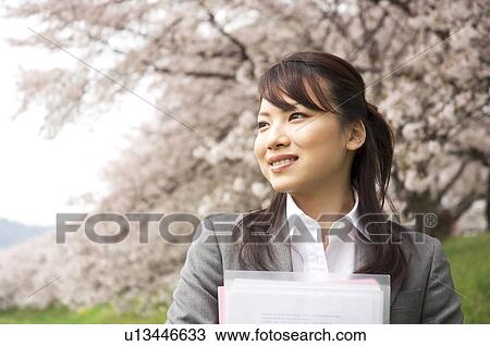 Businesswoman with some paperwork in a field View Large Photo Image Stock Image - Businesswoman with some paperwork in a field. Fotosearch