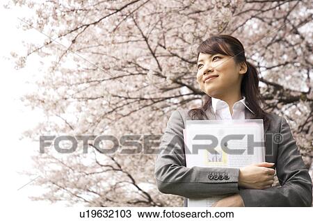 Businesswoman with some paperwork in a field View Large Photo Image Stock Image - Businesswoman with some paperwork in a field. Fotosearch