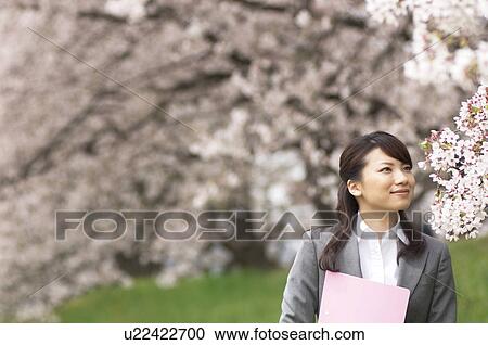 Businesswoman with some paperwork in a field View Large Photo Image Stock Image - Businesswoman with some paperwork in a field. Fotosearch
