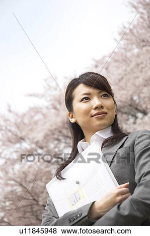Businesswoman with some paperwork in a field View Large Photo Image Stock Photo - Businesswoman with some paperwork in a field. Fotosearch