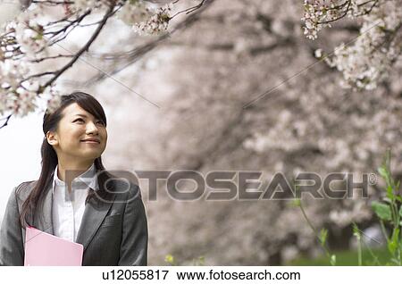 Stock Photo - Businesswoman with some paperwork in a field. Fotosearch