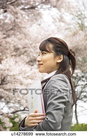 Businesswoman with some paperwork in a field View Large Photo Image Stock Photo - Businesswoman with some paperwork in a field. Fotosearch