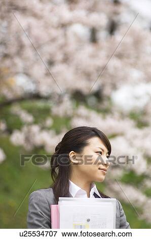 Businesswoman with some paperwork in a field View Large Photo Image Stock Photo - Businesswoman with some paperwork in a field. Fotosearch