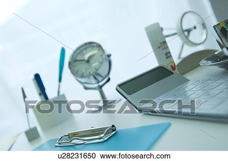 Stock Image - Calculator and clipboard on desk. Fotosearch