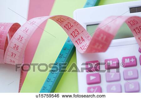 Calculator and tape measure on desk View Large Photo Image Stock Photograph - Calculator and tape measure on desk. Fotosearch