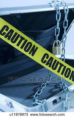 Stock Image - Case with laptop covered in chains and cordon tape. Fotosearch