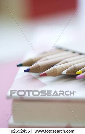 Stock Image - Coloring pencils on book. Fotosearch