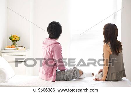 Stock Photograph - Couple sitting on a hospital bed. Fotosearch