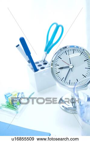 Stock Photo - Desk with clock and office supplies. Fotosearch