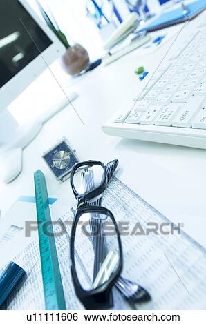 Stock Photograph - Desk with glasses, ruler, document and wristwatch. Fotosearch