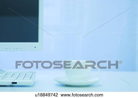 Stock Image - Desktop PC and coffee cup. Fotosearch
