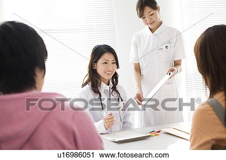 Stock Image - Doctor and nurse consulting with a couple. Fotosearch