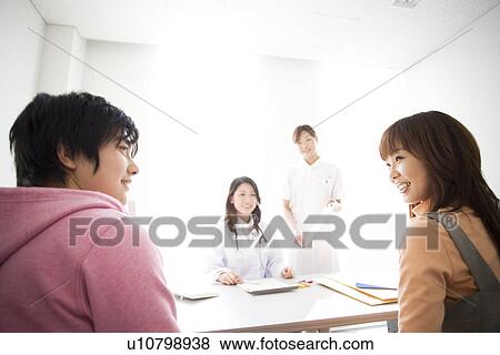 Doctor and nurse consulting with a couple View Large Photo Image Stock Photo - Doctor and nurse consulting with a couple. Fotosearch