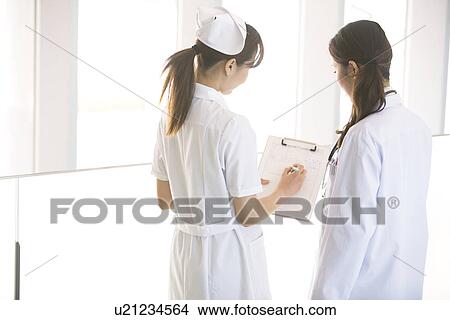 Picture - Doctor and nurse looking at chart. Fotosearch