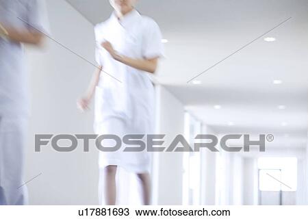 Stock Image - Doctor and nurse running through hospital. Fotosearch
