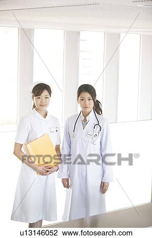Doctor and nurse smiling at the camera View Large Photo Image Stock Image - Doctor and nurse smiling at the camera. Fotosearch