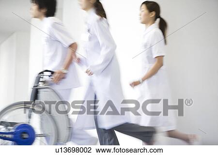 Doctor and nurses running through hospital View Large Photo Image Stock Image - Doctor and nurses running through hospital. Fotosearch