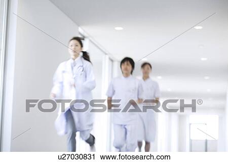 Stock Image - Doctor and nurses running through hospital. Fotosearch