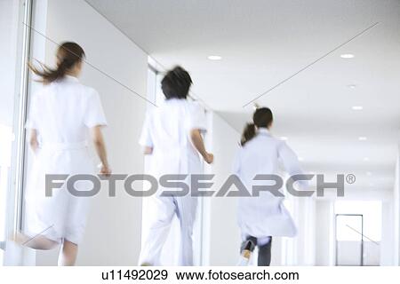 Doctor and nurses running through hospital View Large Photo Image Stock Photo - Doctor and nurses running through hospital. Fotosearch