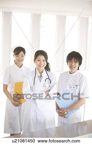 Stock Image - Doctor and two nurses smiling at the camera. Fotosearch