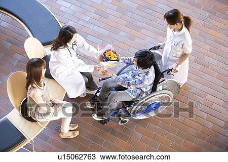 Doctor giving patient a bunch of flowers as he leaves hospital View Large Photo Image Stock Image - Doctor giving patient a bunch of flowers as he leaves hospital. Fotosearch