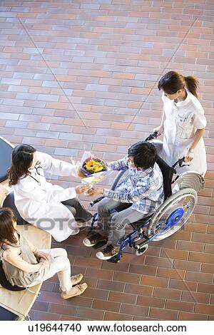 Doctor giving patient a bunch of flowers as he leaves hospital View Large Photo Image Stock Image - Doctor giving patient a bunch of flowers as he leaves hospital. Fotosearch