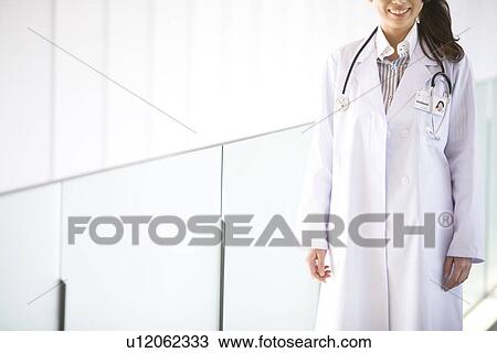 Stock Image - Doctor smiling at the camera. Fotosearch