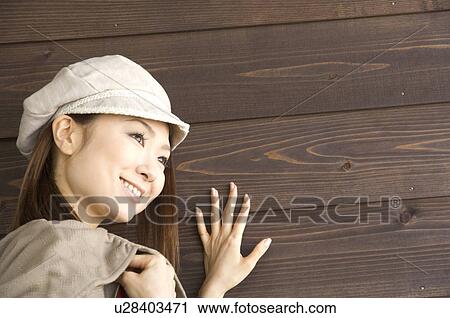 Fashionable woman against brown wooden wall View Large Photo Image Stock Image - Fashionable woman against brown wooden wall. Fotosearch